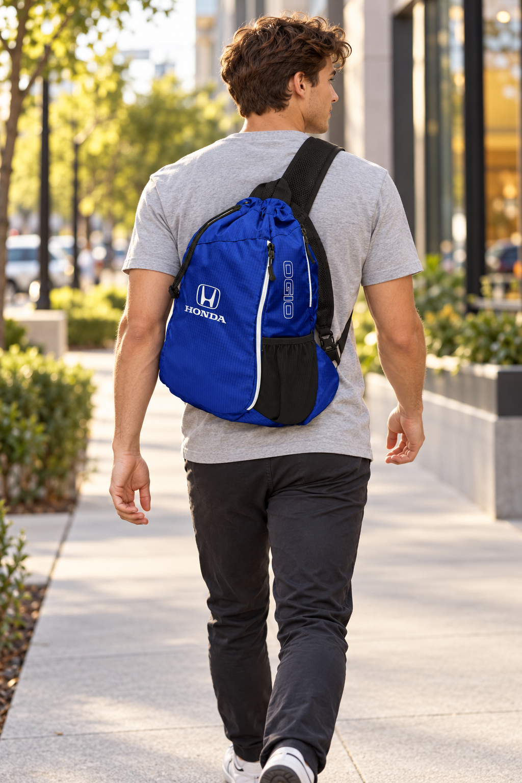 Royal blue Honda OGIO sling bag worn over a gray T-shirt.